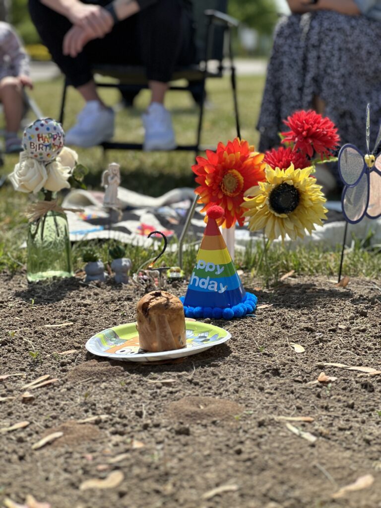 birthday hat on grave with panettone and sparkler