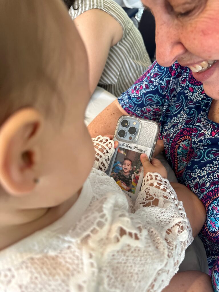 Isabella at her birthday looking at Charlie's picture with Nanny