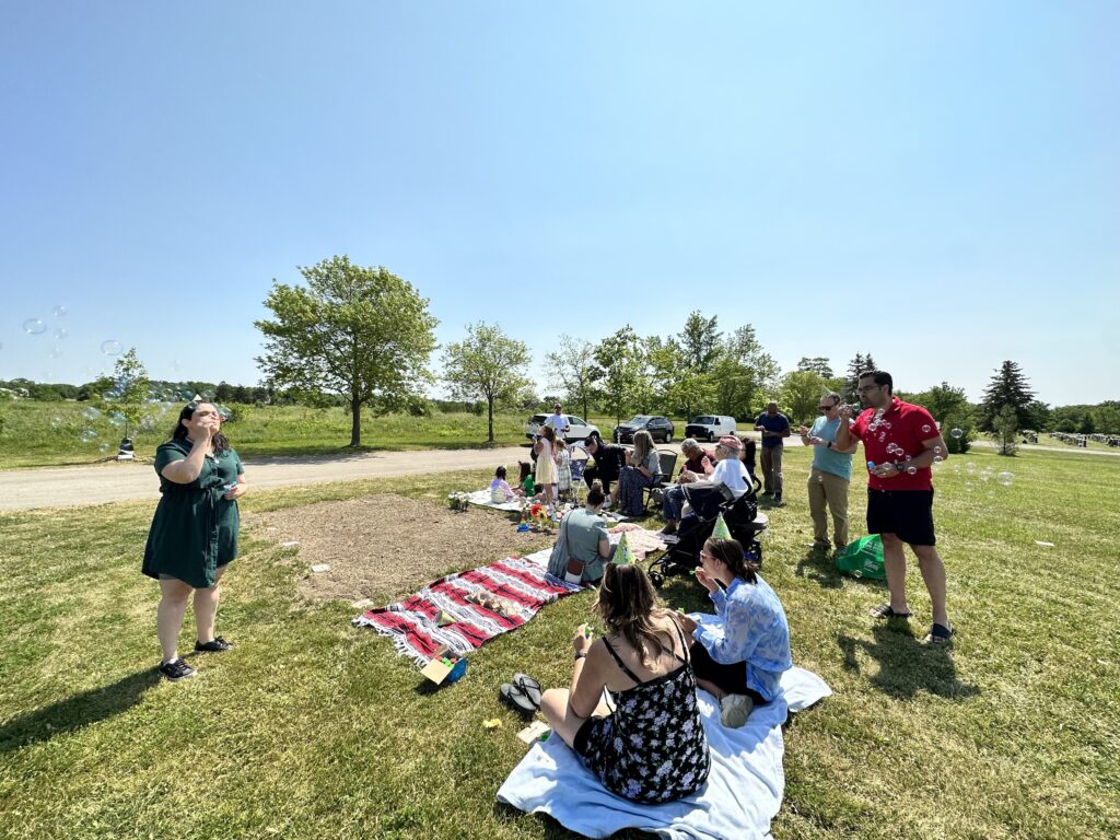 family sitting in chairs and on blankets around the grave